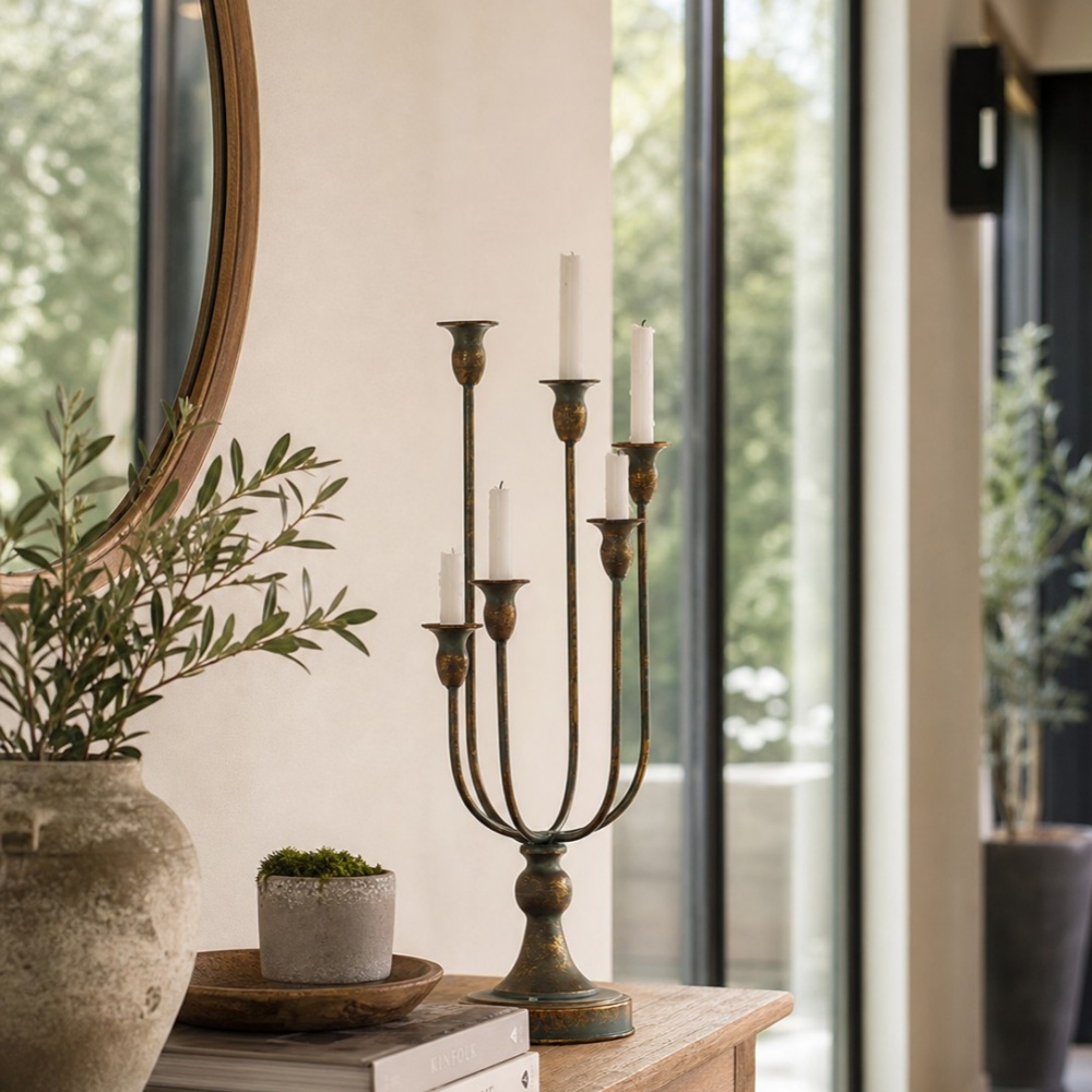 candle holder beside greenery and a mirror