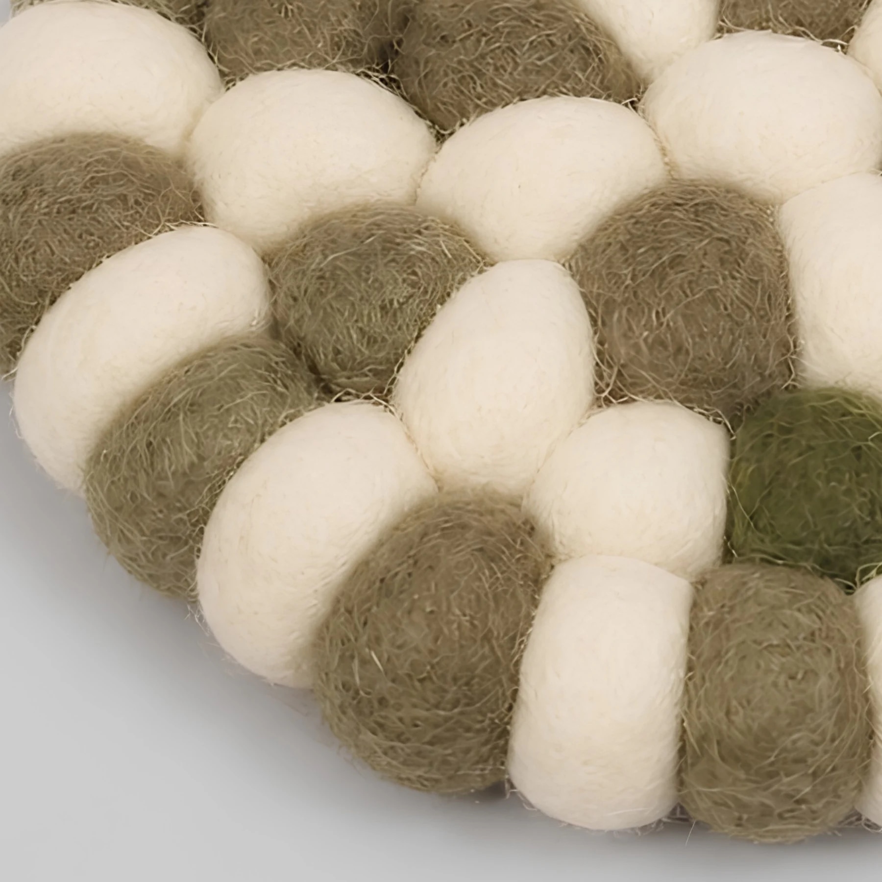 Close view of round felt ball coaster edge